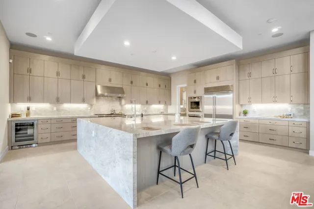 a kitchen with stainless steel appliances a stove a sink and a refrigerator