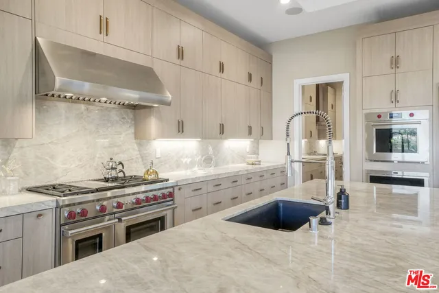 a large kitchen with kitchen island a large window in it