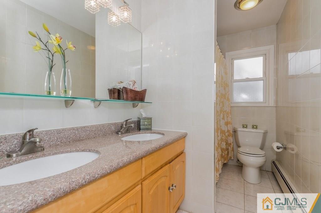 53 Lynnwood Road Edison, NJ 08820 - Photo 14 of 19 a bathroom with a granite countertop sink a toilet and a mirror