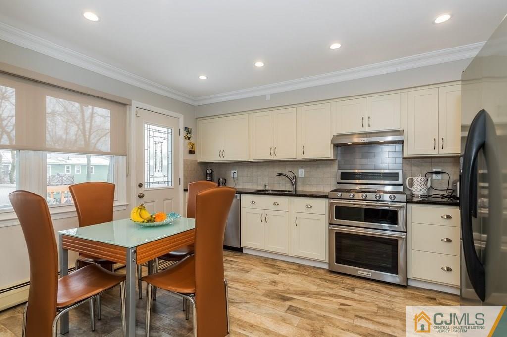 53 Lynnwood Road Edison, NJ 08820 - Photo 5 of 19 a kitchen with stainless steel appliances granite countertop a stove a sink a microwave a dining table and chairs