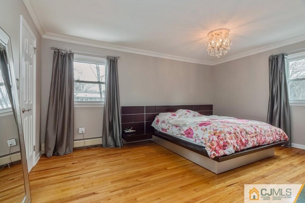 53 Lynnwood Road Edison, NJ 08820 - Photo 8 of 19 a bedroom with a bed and a chandelier