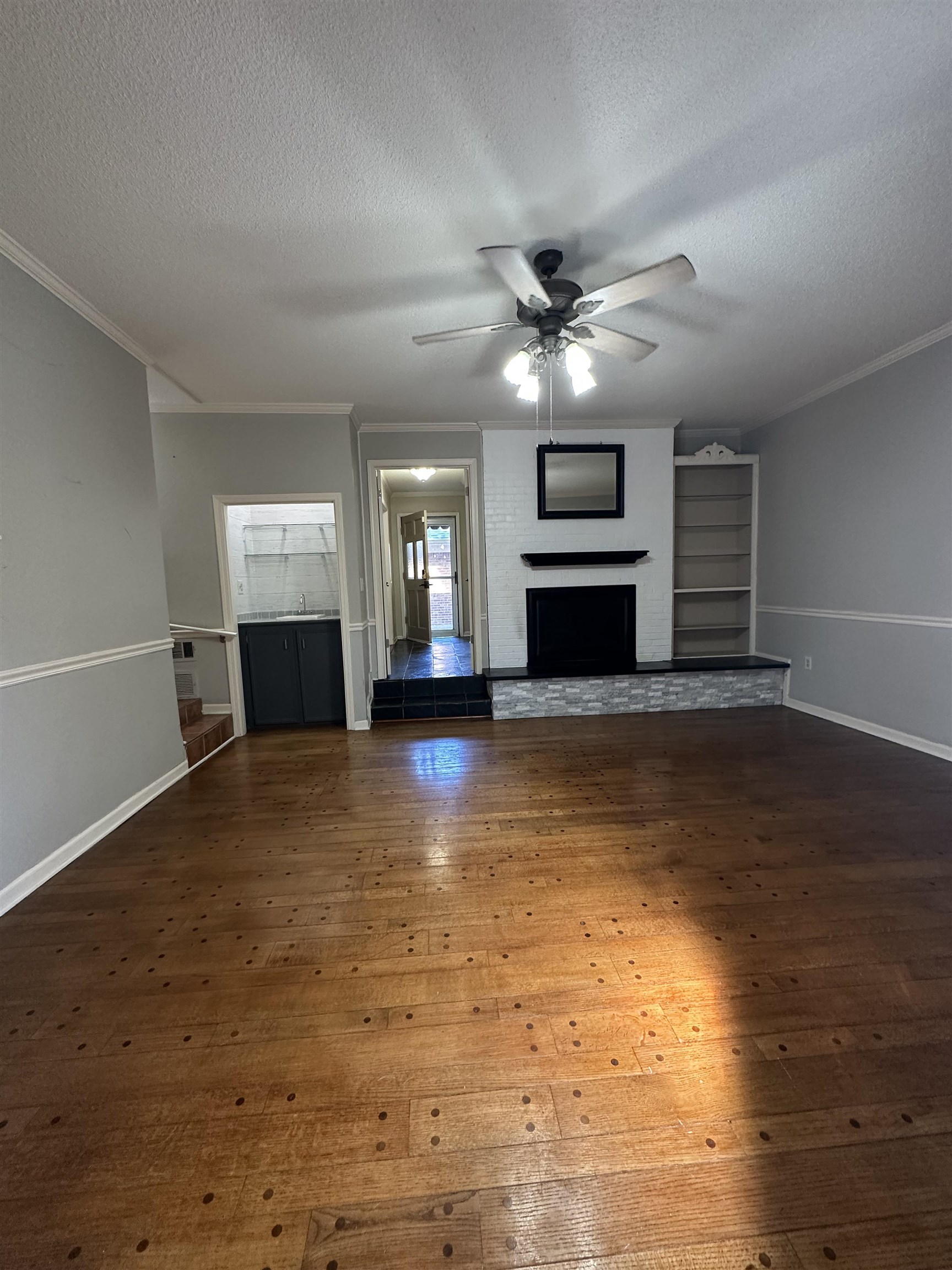 6939 Amberly Road, Unit 6939 Memphis, TN 38119 - Photo 3 of 14 a view of a livingroom with a fireplace a ceiling fan and kitchen view