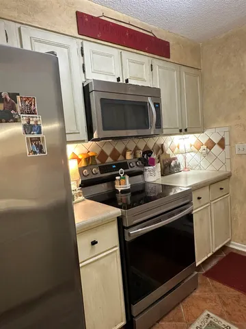 a kitchen with stainless steel appliances a stove a microwave and a sink