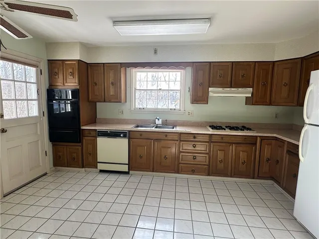 a kitchen with a sink window and cabinets