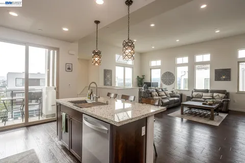 a view of a kitchen and dining room with wooden floor a chandelier