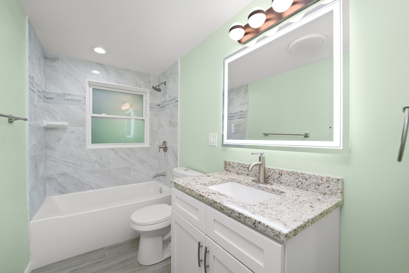 13228 South Rhodes Avenue Chicago, IL 60827 - Photo 6 of 16 a bathroom with a granite countertop sink a toilet a mirror and bathtub