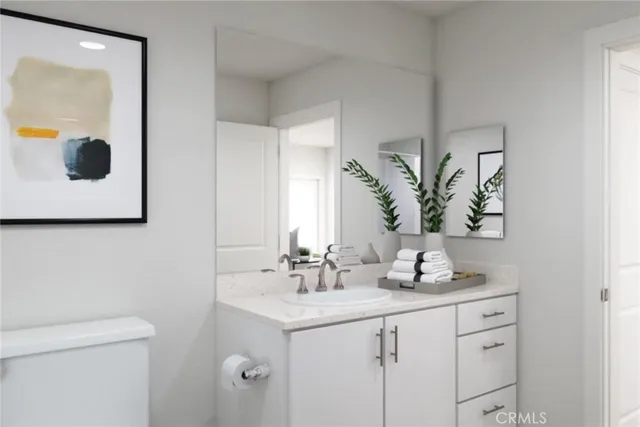 a bathroom with a granite countertop sink a toilet and mirror