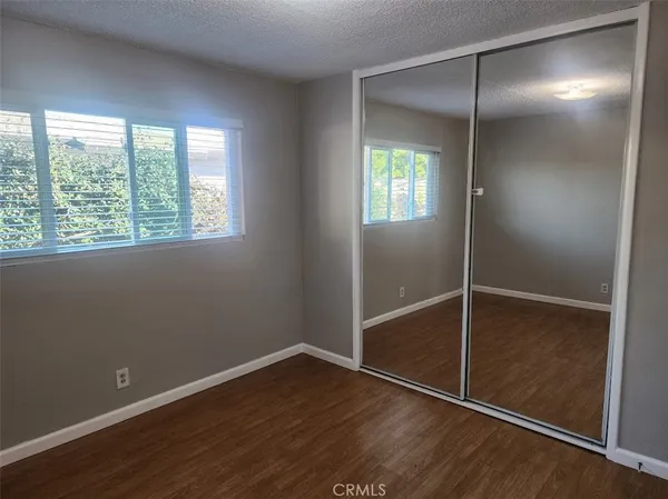 an empty room with wooden floor and closet