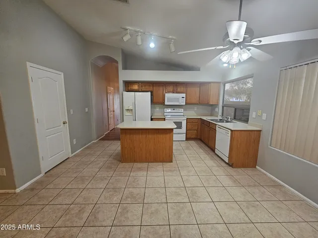 a large kitchen with granite countertop a stove a sink dishwasher and a refrigerator