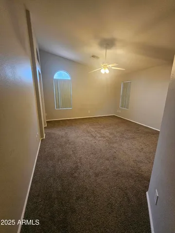 a view of a room with a ceiling fan and window