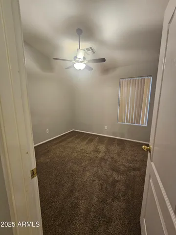 en empty room with windows and fan