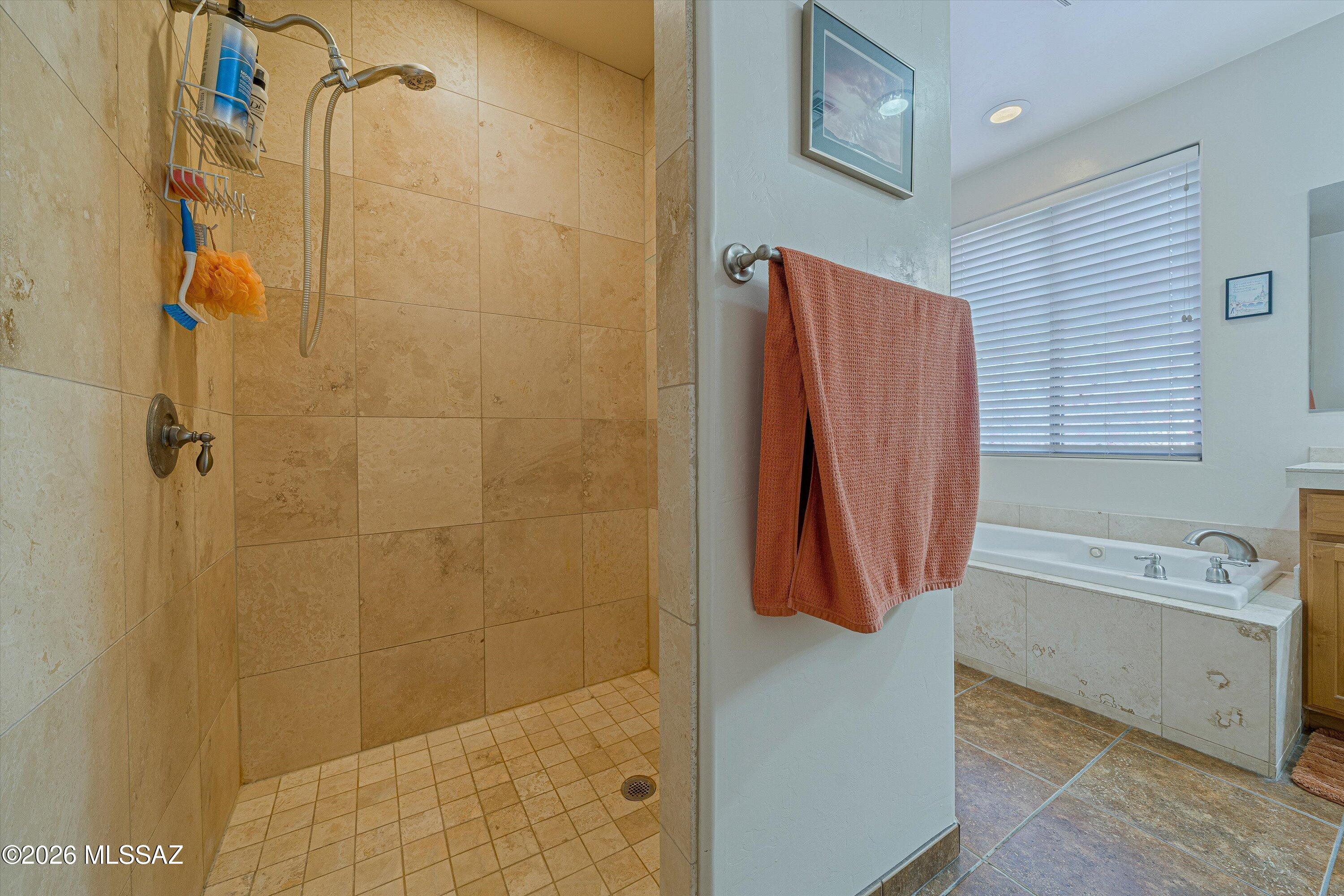 4677 East Rail N Road Tucson, AZ 85739 - Photo 15 of 48 Left from great room and kitchen is this en-suite Wing with walk in tiled shower, soaking tub, walk in closet and patio door to pool oasis