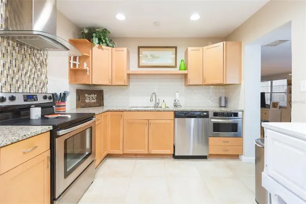 a kitchen with stainless steel appliances granite countertop a stove sink and cabinets