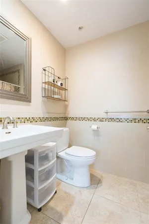 a bathroom with a sink mirror and toilet