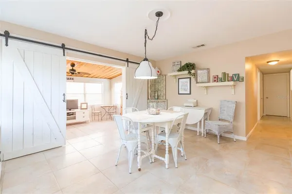 a dining room with stainless steel appliances kitchen island granite countertop a table chairs and a view of living room