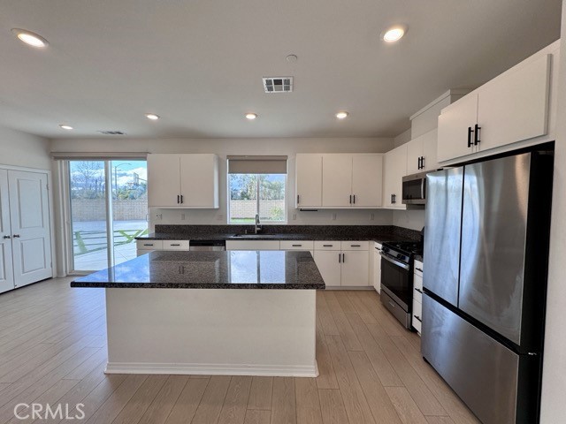 30115 Adrift Lane Menifee, CA 92584 - Photo 11 of 60 a large kitchen with stainless steel appliances and a refrigerator