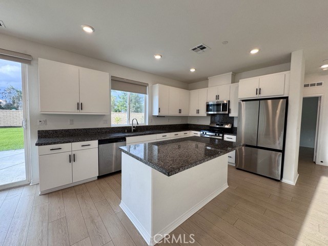 30115 Adrift Lane Menifee, CA 92584 - Photo 14 of 60 a kitchen with a sink a refrigerator a microwave and cabinets
