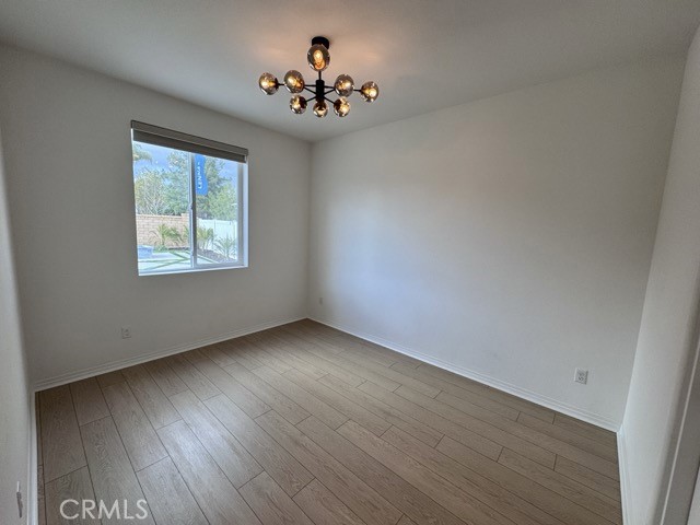 30115 Adrift Lane Menifee, CA 92584 - Photo 17 of 60 a view of an empty room with wooden floor and a window