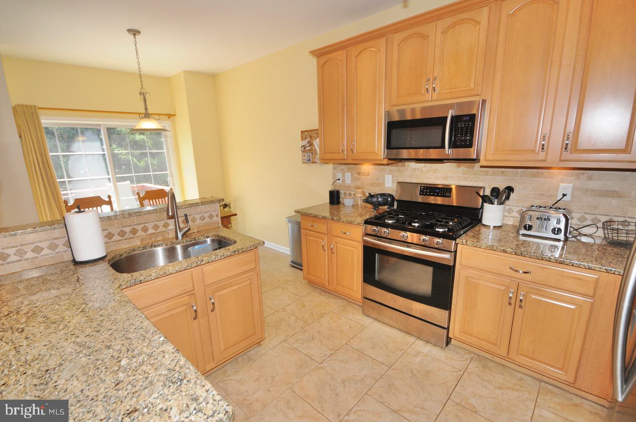 349 Huntington Drive Delran, NJ 08075 - Photo 7 of 68 a kitchen with stainless steel appliances granite countertop a stove a sink and a microwave