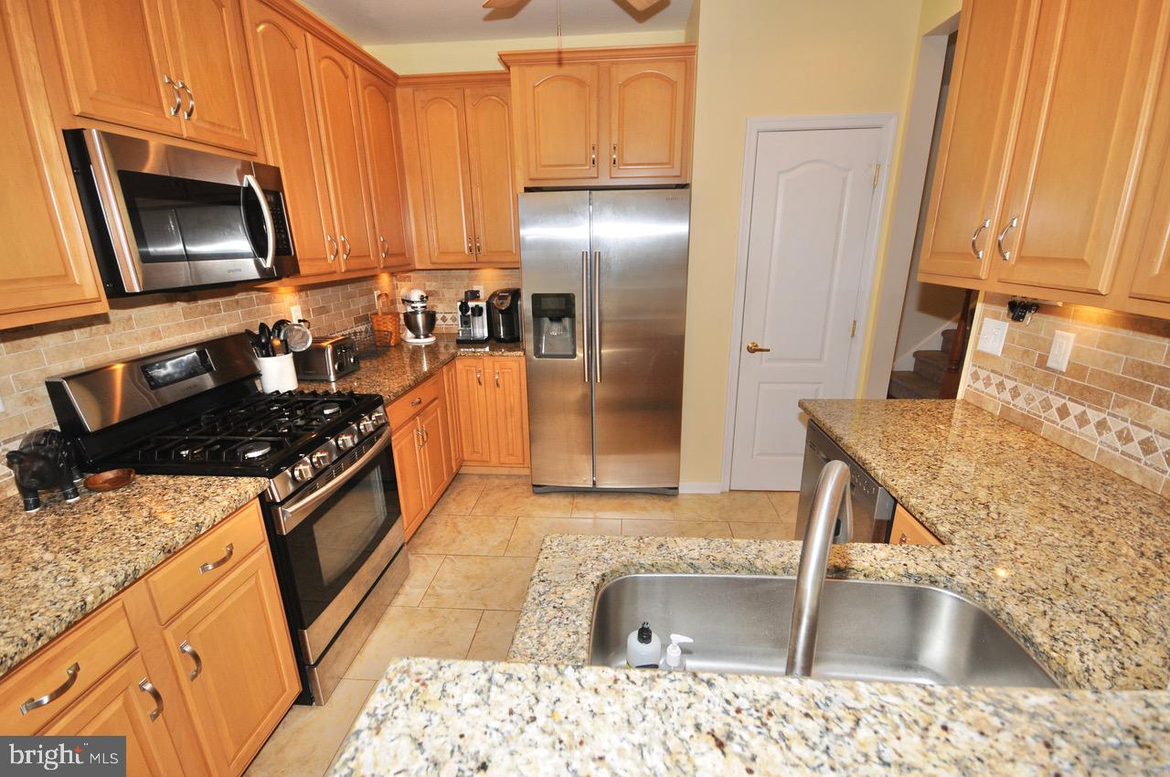 349 Huntington Drive Delran, NJ 08075 - Photo 8 of 68 a kitchen with stainless steel appliances granite countertop a sink stove and refrigerator