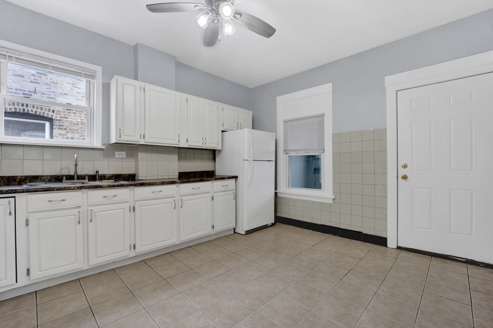 5015 West Montrose Avenue, Unit 2 Chicago, IL 60641 - Photo 4 of 23 a kitchen with granite countertop white cabinets white appliances with a sink and dishwasher