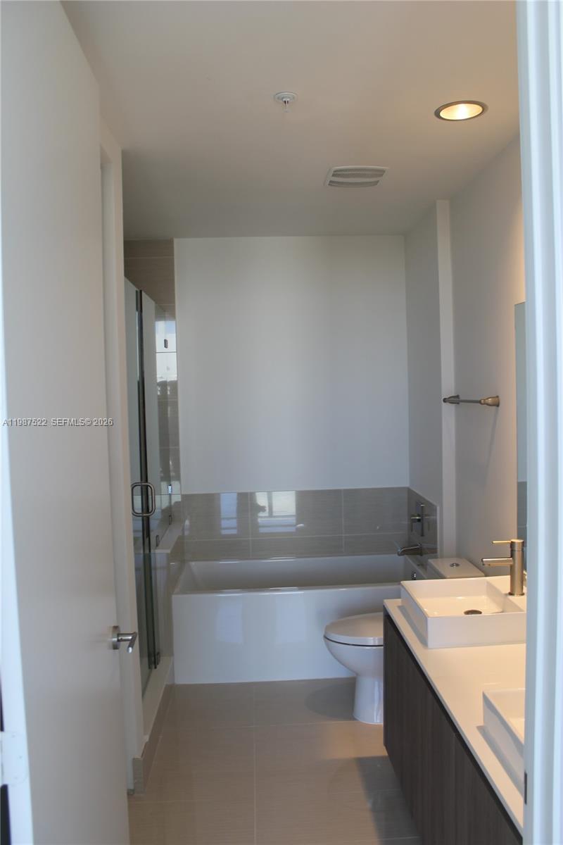 201 Southwest 17th Road, Unit 802 Miami, FL 33129 - Photo 11 of 20 a bathroom with a tub a toilet and a shower