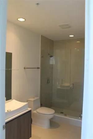 a bathroom with a shower a toilet and a sink