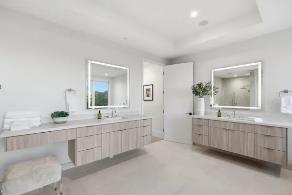 a large bathroom with a double vanity sink and mirror with bathtub