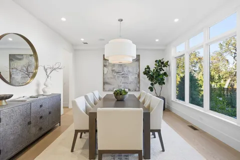 a dining room with furniture a rug and a large window