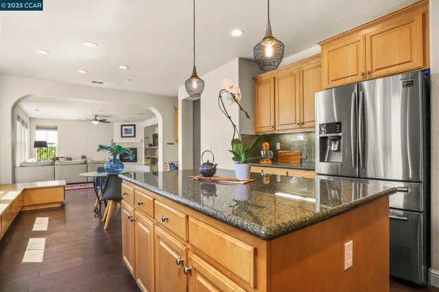a kitchen with stainless steel appliances granite countertop a sink a stove and a refrigerator