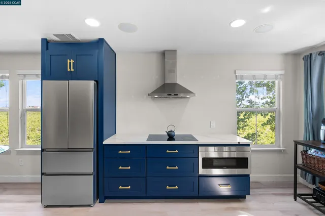 a kitchen with stainless steel appliances granite countertop a refrigerator a stove and a window