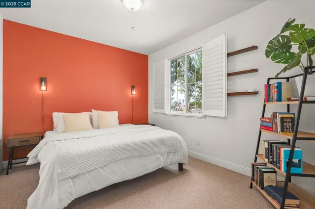 a bedroom with a bed a dresser and a window