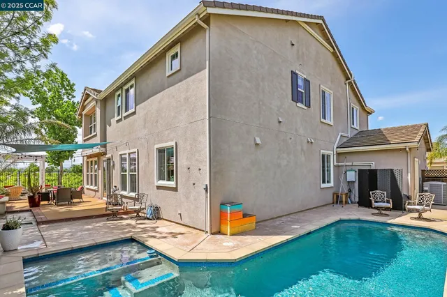 a front view of a house with a yard and potted plants