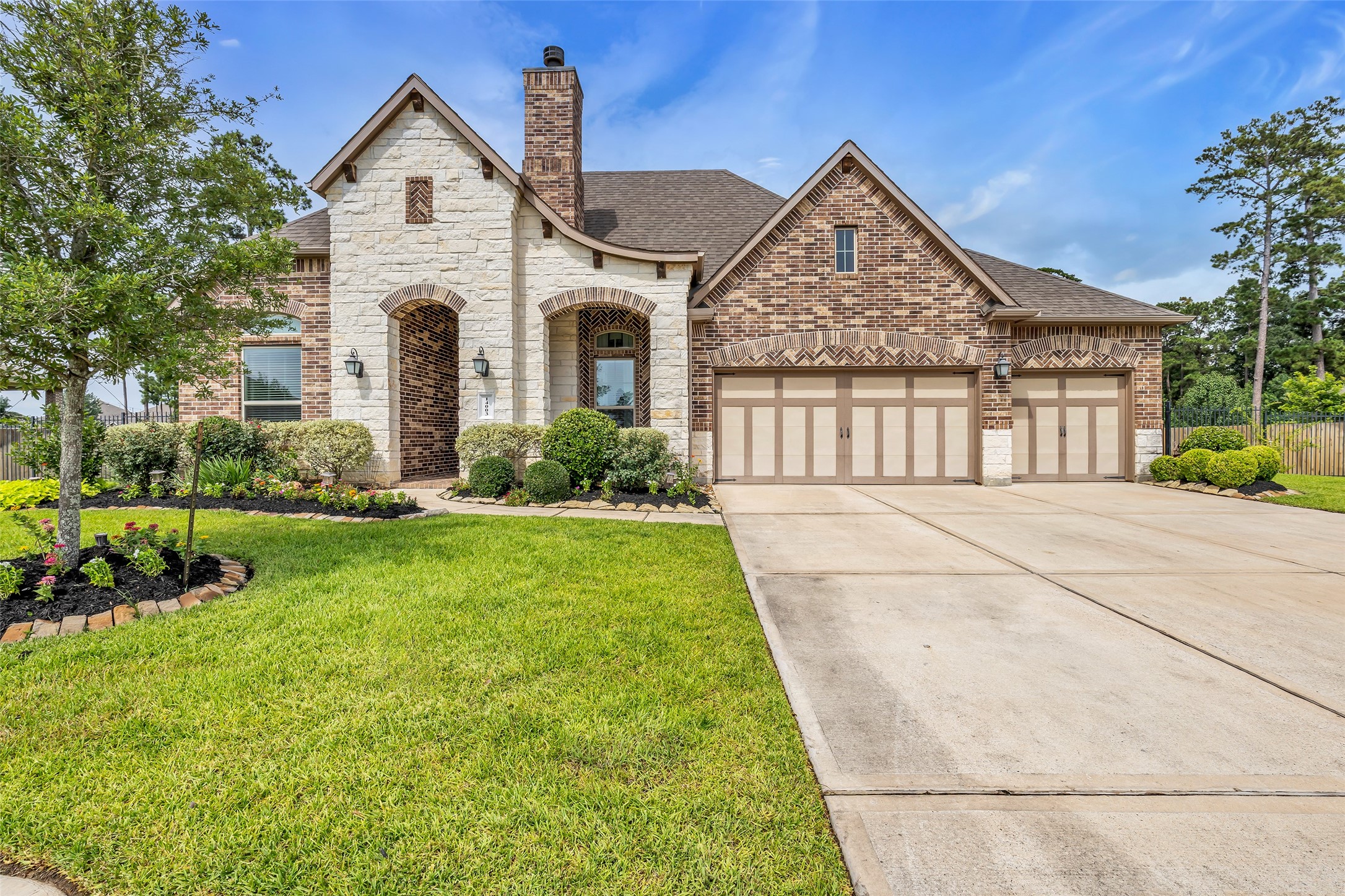 14003 South Evergreen Ridge Court Conroe, TX 77384 - Photo 1 of 43 Elegant former Emerald Homes model with exceptional curb appeal showcasing a Texas limestone and brick exterior in the gated Jasper's Lodge section of Fosters Ridge.