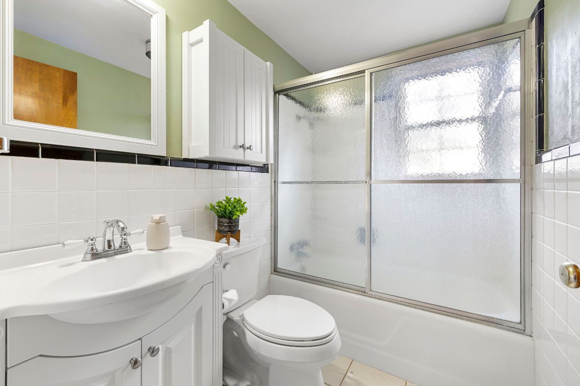 315 Flying R Ranch Road Spring Branch, TX 78070 - Photo 18 of 39 Bathroom with vanity, tile walls, shower / bath combination with glass door, decorative backsplash, and light tile patterned flooring