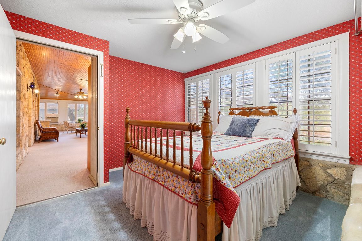 315 Flying R Ranch Road Spring Branch, TX 78070 - Photo 19 of 39 Carpeted bedroom with wallpapered walls and a ceiling fan
