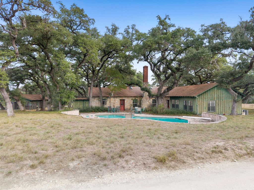 315 Flying R Ranch Road Spring Branch, TX 78070 - Photo 23 of 39 Rear view of property with a chimney, a patio, a lawn, and an outdoor pool
