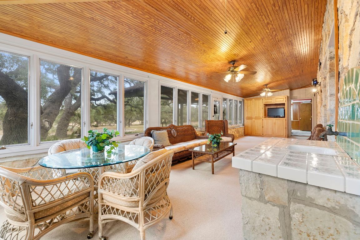 315 Flying R Ranch Road Spring Branch, TX 78070 - Photo 8 of 39 Sunroom featuring carpet floors, wooden ceiling, and wooden walls