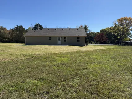 a view of a field with trees in the background