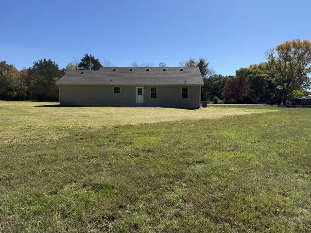 a view of a field with trees in the background