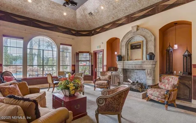 a living room with furniture fireplace and a large window