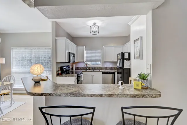 a kitchen with kitchen island granite countertop a sink and cabinets