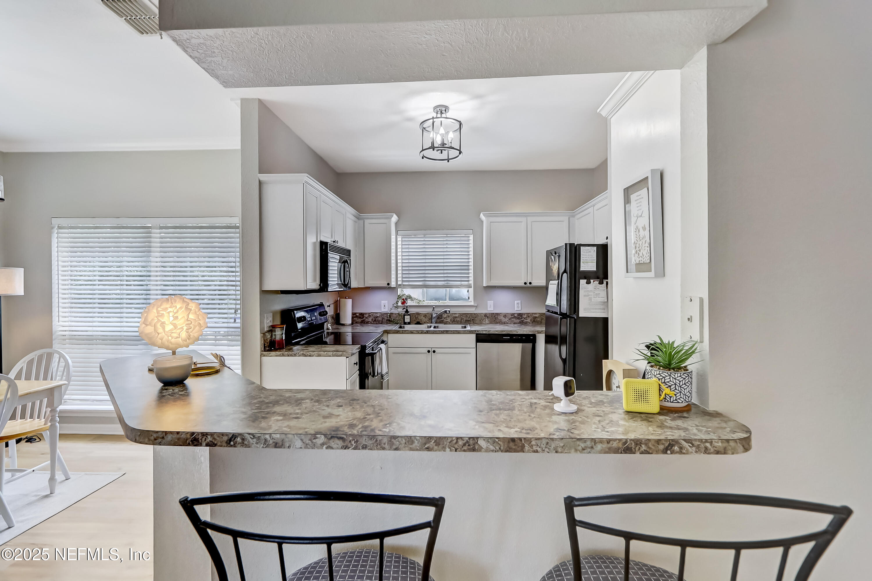 10961 Burnt Mill Road, Unit 328 Jacksonville, FL 32256 - Photo 5 of 33 a kitchen with kitchen island granite countertop a sink and cabinets
