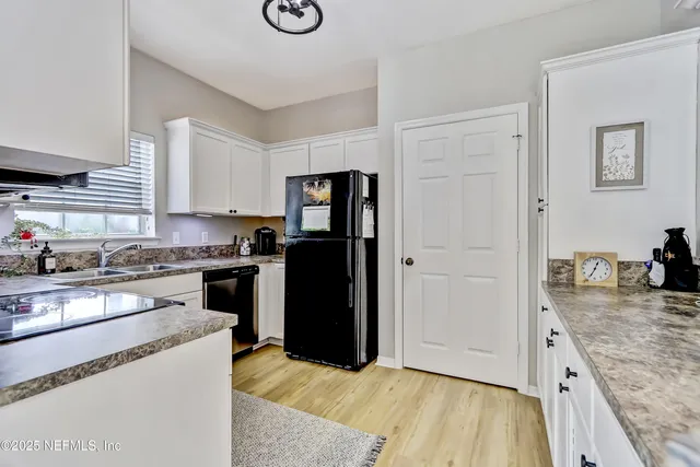 a kitchen with a refrigerator and a stove top oven