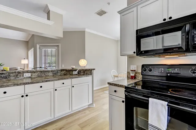 a kitchen with granite countertop a stove microwave and sink