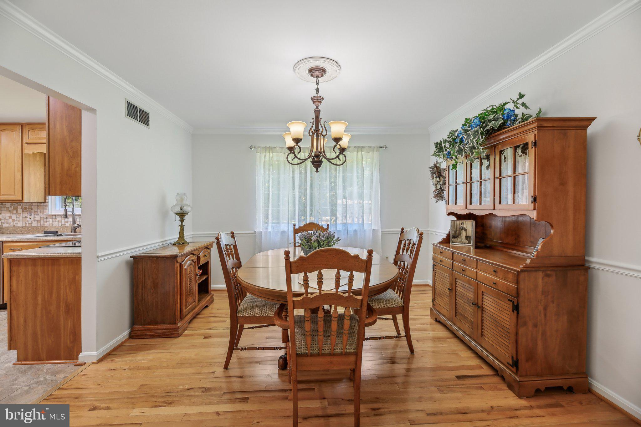 9202 Stone Spring Lane Pasadena, MD 21122 - Photo 11 of 43 a view of a dining room with furniture and chandelier