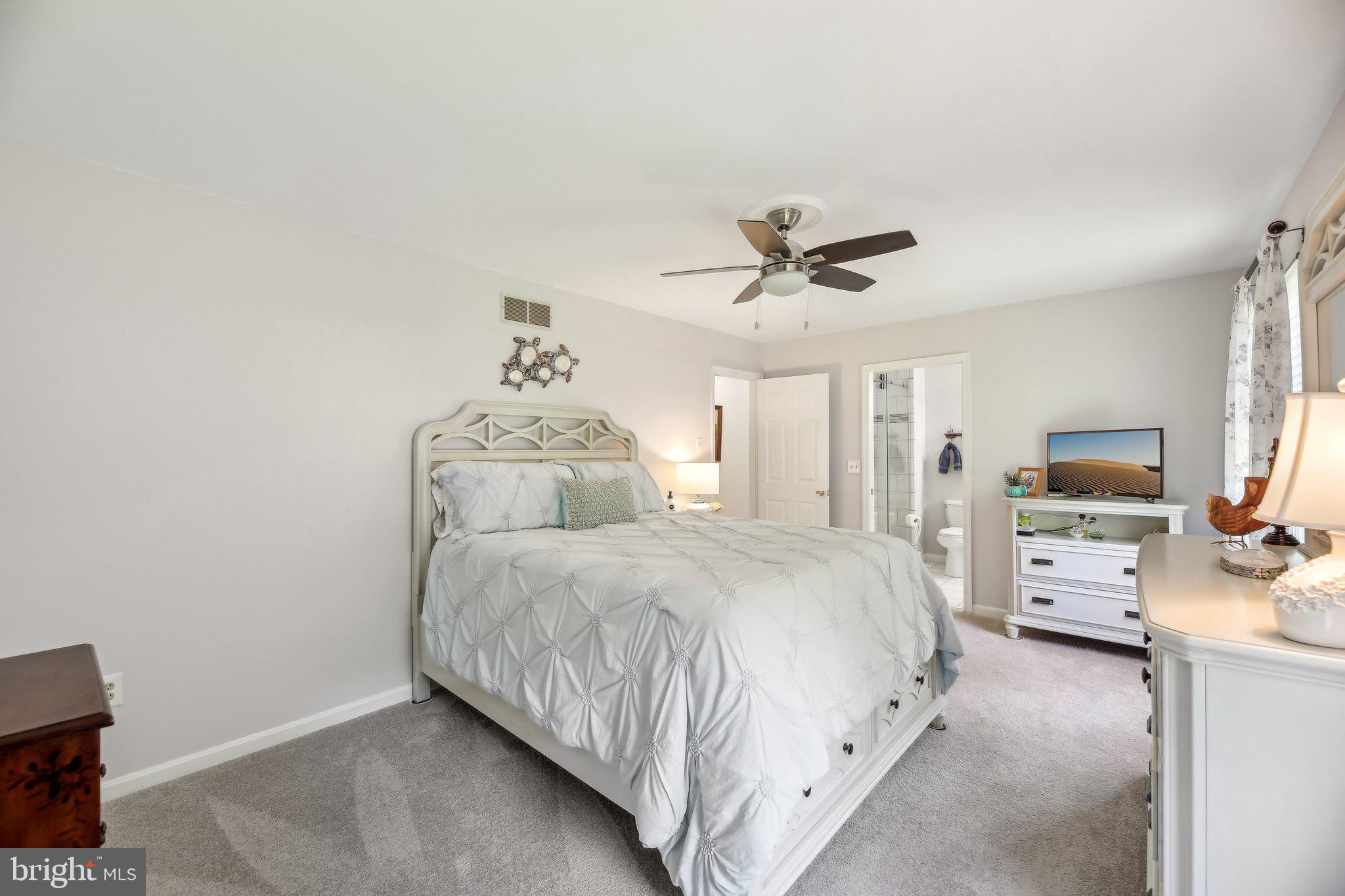 9202 Stone Spring Lane Pasadena, MD 21122 - Photo 24 of 43 a spacious bedroom with a bed a window and a television