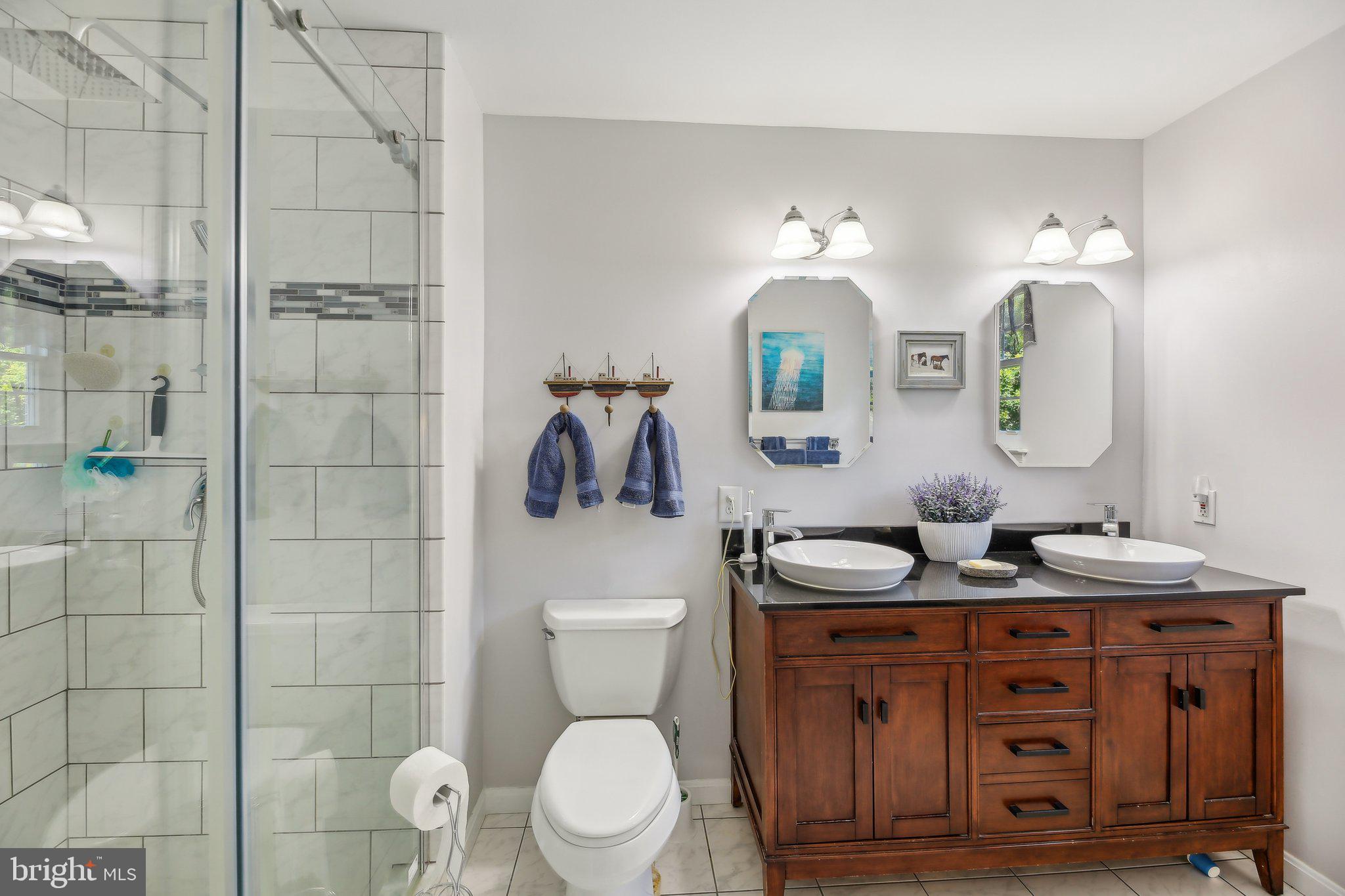 9202 Stone Spring Lane Pasadena, MD 21122 - Photo 25 of 43 a bathroom with a toilet a sink a mirror a lamp and vanity