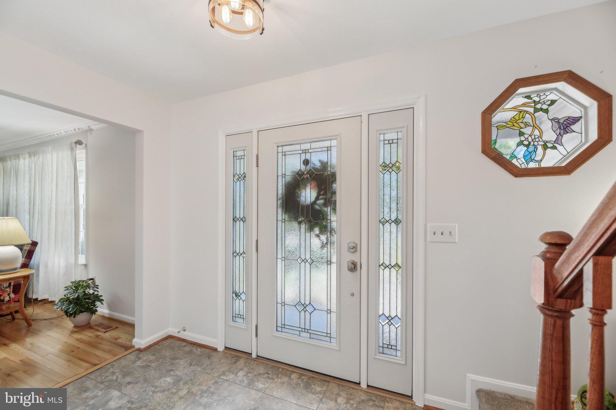 9202 Stone Spring Lane Pasadena, MD 21122 - Photo 6 of 43 a view of a hallway with paintings on the wall