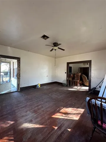 a view of a livingroom with wooden floor and a ceiling fan